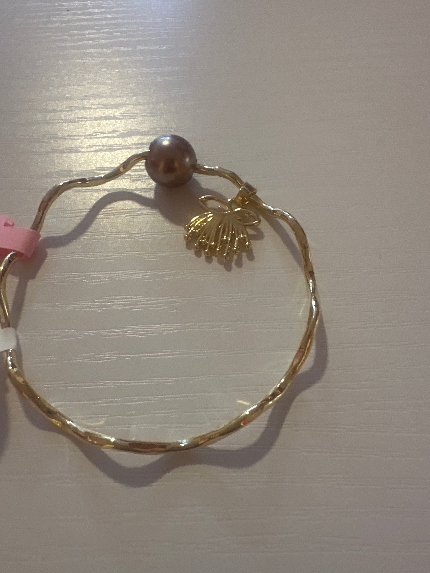 Wave gold bangle with Ohia Lehua charm